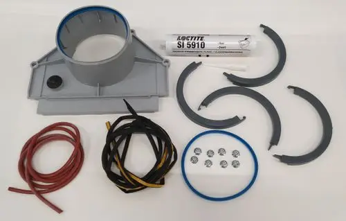 Remeha Deckplatte für einen Kondensatsammler, bestehend aus einer grauen Grundplatte, Dichtungsringen, Schrauben und Kabeln. Auf dem Bild sind verschiedene Zubehörteile neben der Platte angeordnet.